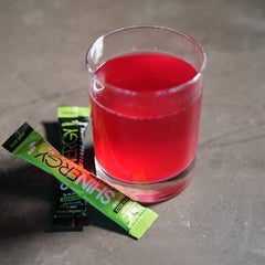 Shinergy drink mixed in a glass with Daytime and Nighttime stick packs