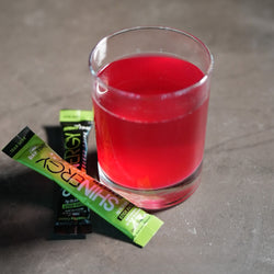 Shinergy drink mixed in a glass with Daytime and Nighttime stick packs